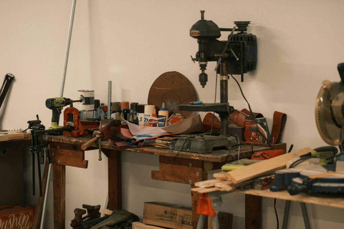 Miter saw hand tool cutting crown molding on a stable workbench with dust collection